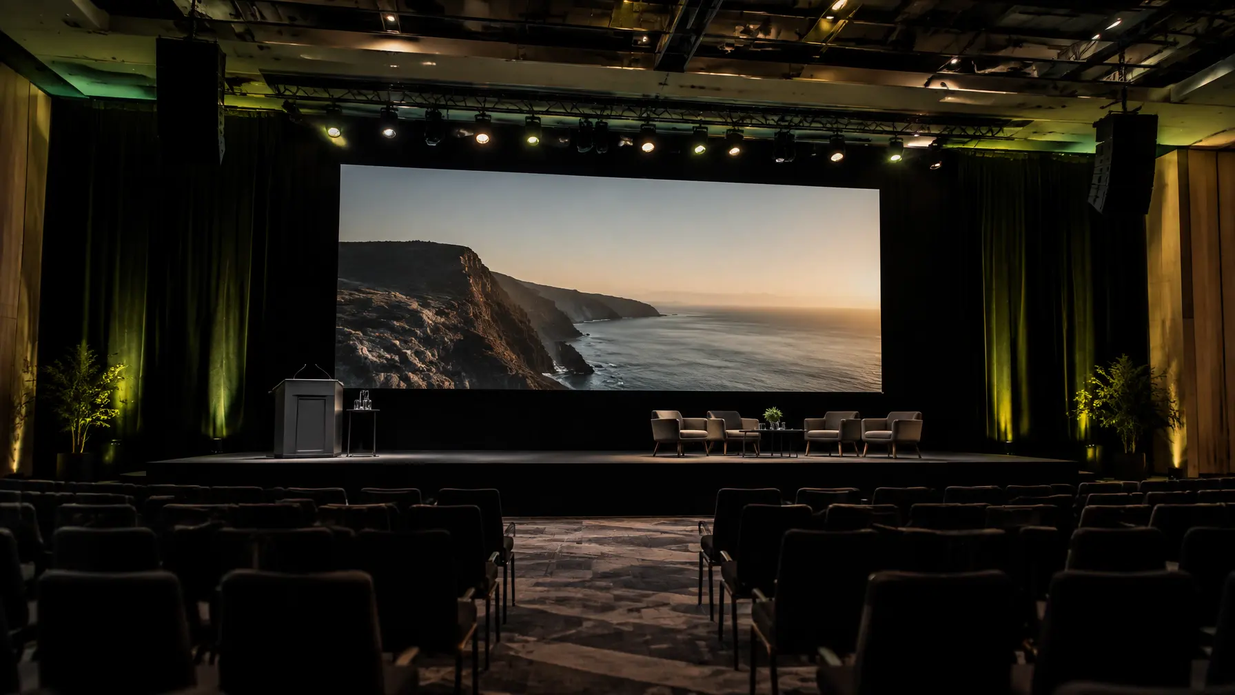 Dark conference stage with a wide presentation screen